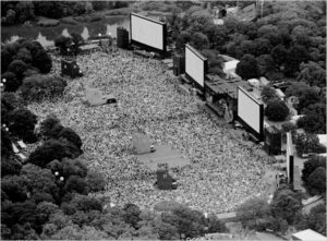 Black and White photo of four screens and 500,000 people on the Great Lawn