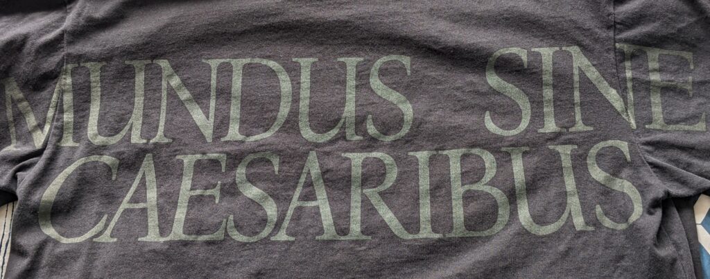 Black t-shirt with the words Mundus Sine Caesaribus on it.