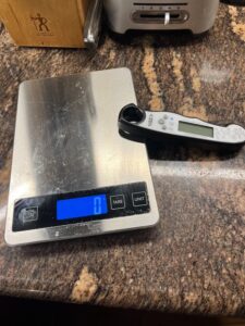 Rectangular stainless steel electronic scale, and folded instant-read thermometer.